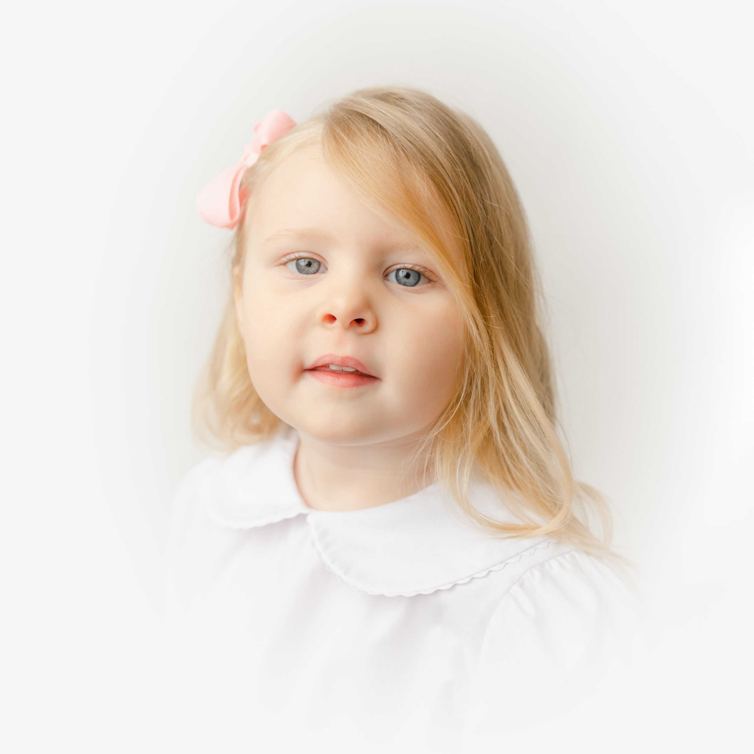 Lily wears a pink bow during her Heirloom Portrait.