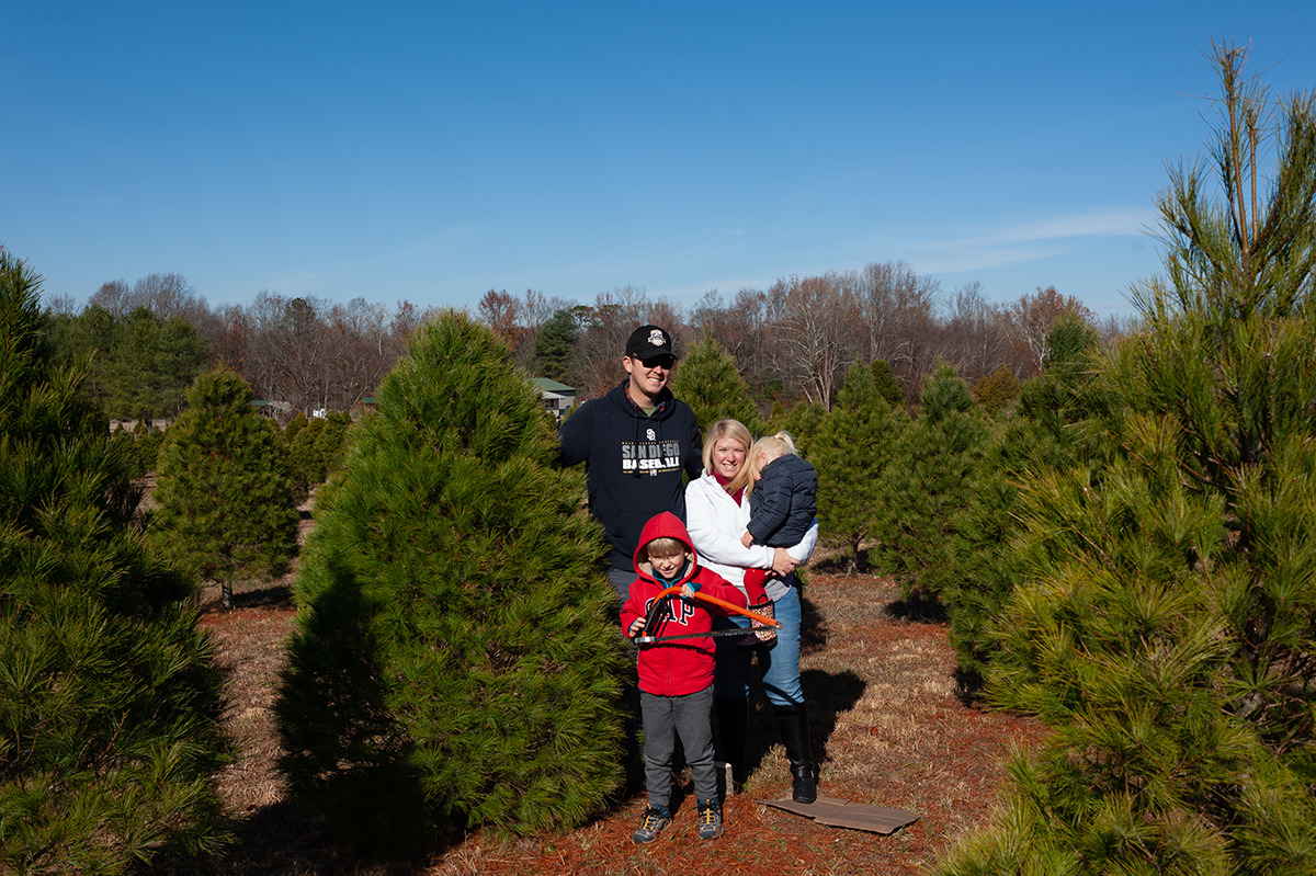 family standing next to their Christmas tree