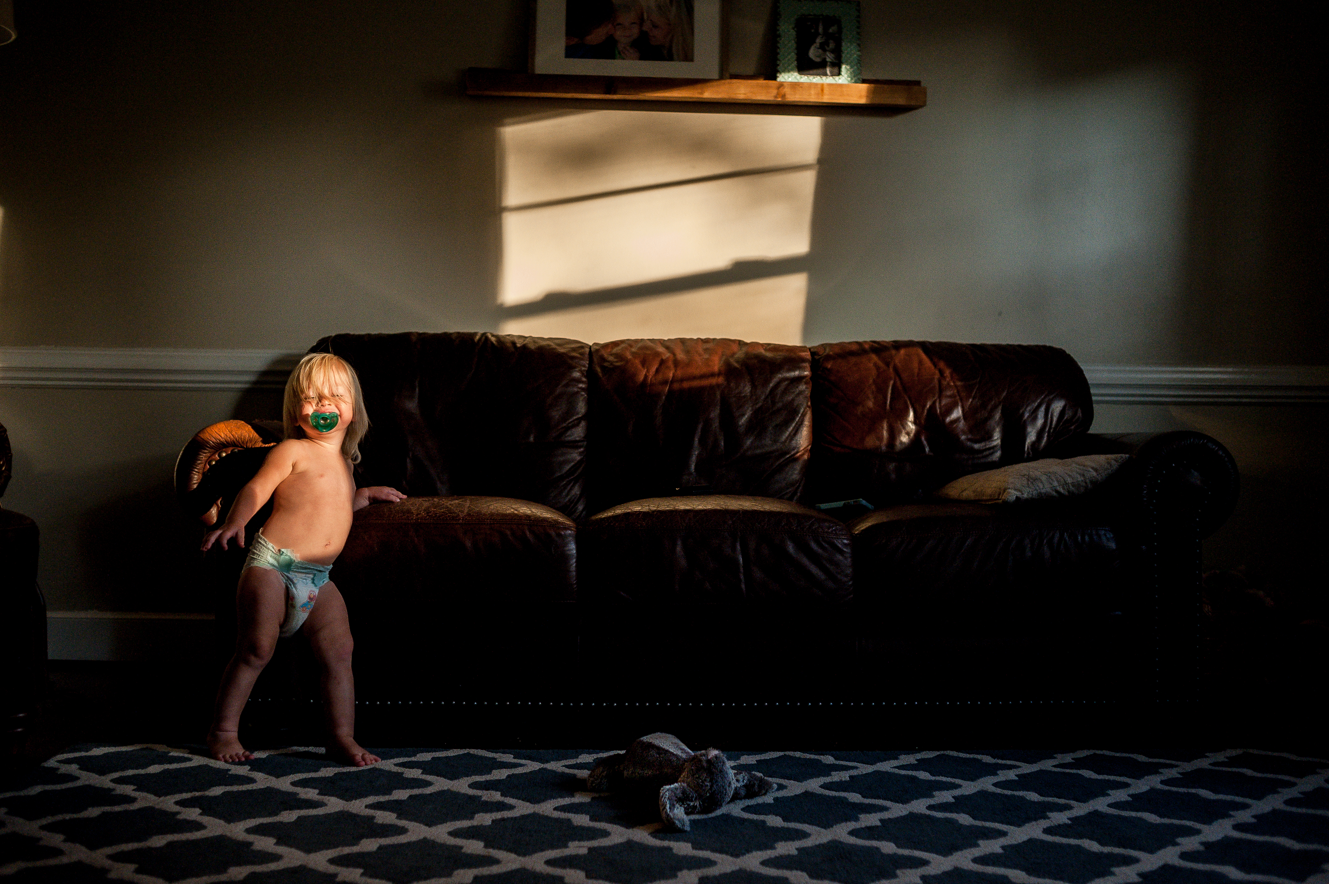Girl inside in front of couch in her diaper