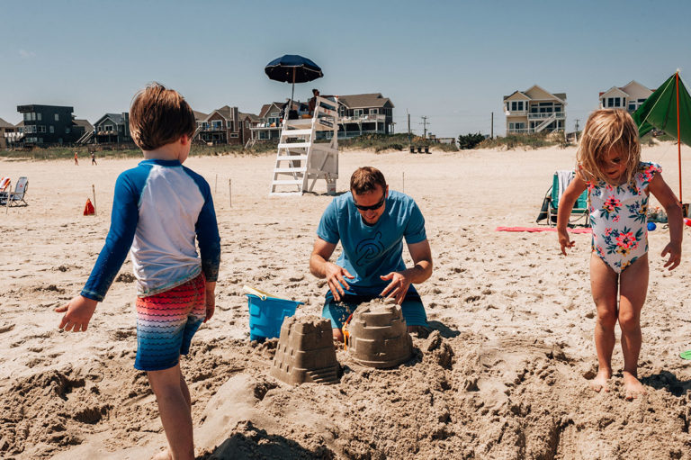 Dad builds sandcastles during family vacation in Nags, Head North Carolina.