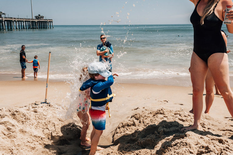Mom dumps bucket of water on children at beach in Nags Head, NC.