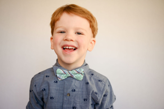 Boy laughs during preschool portrait with Dreama Spence.