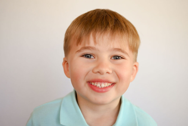 Boy gives a natural smile for school portrait.