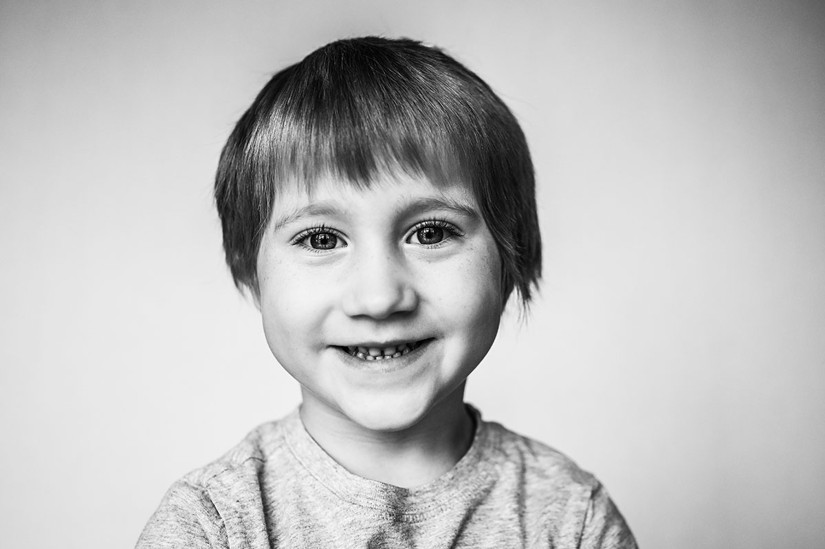 Little boys eyes sparkle during preschool portrait.