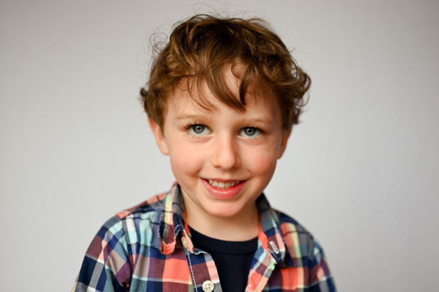 Boy smiles for preschool portrait photographer Dreama Spence.
