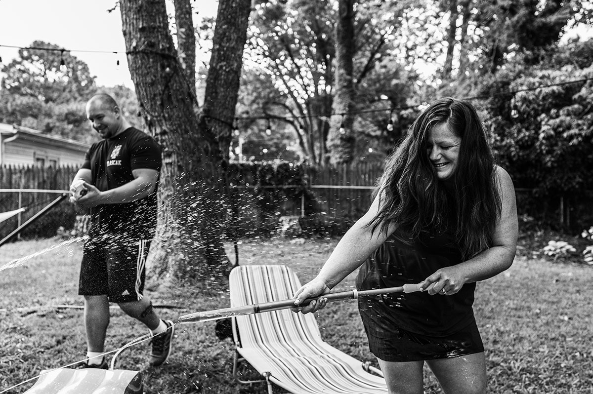 Parents laugh as they squirt their daughter with water guns during a mini story session in Newport News.