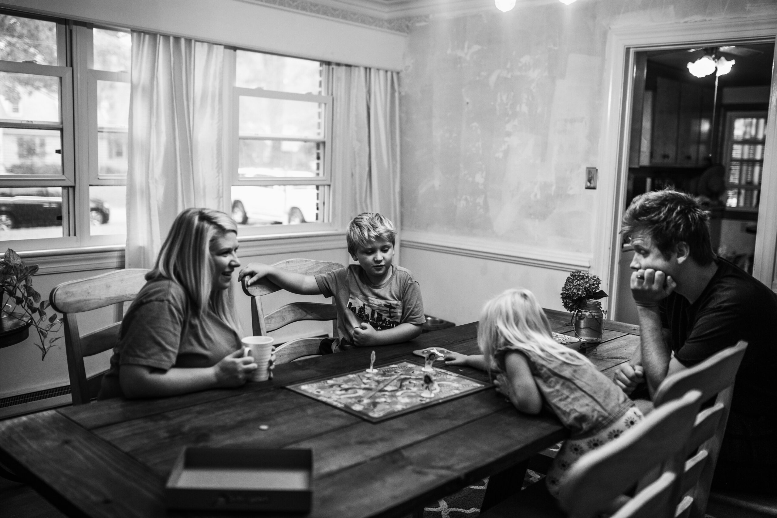 Dreama plays board game with family during family session.