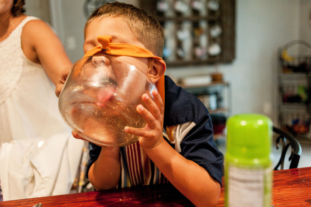 Little boy licks muffin bowl during their in-home family session with Dreama Spence.