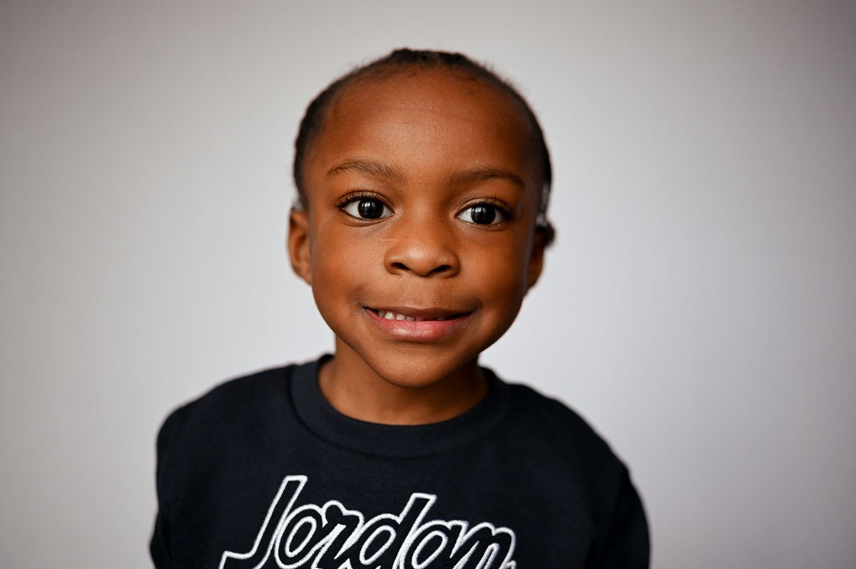 Little boy smiles during his school portrait.