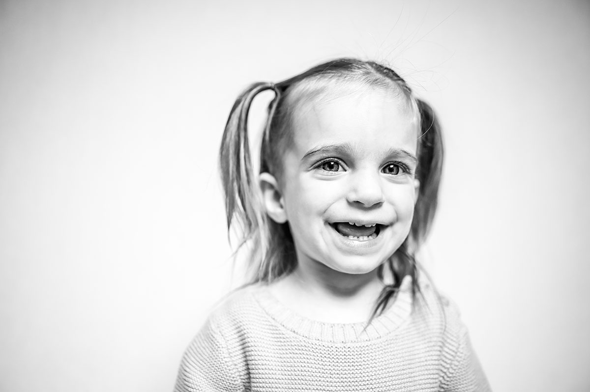 Little girl with pig-tails smiles for camera.