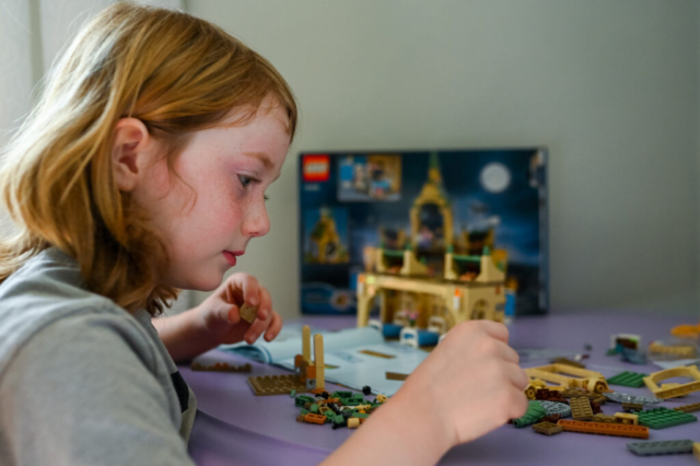Boy plays puts together Harry Potter Legos during in-home family session.