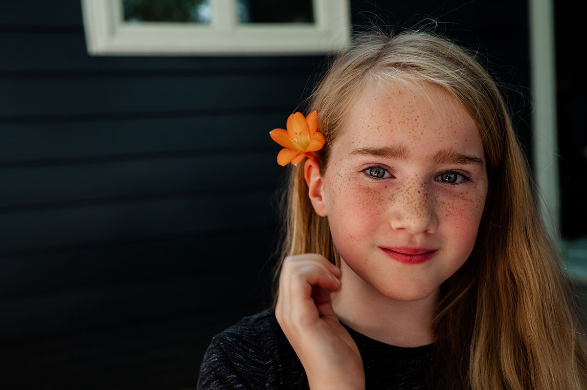 Olivia sticks an orange flower in her hair.