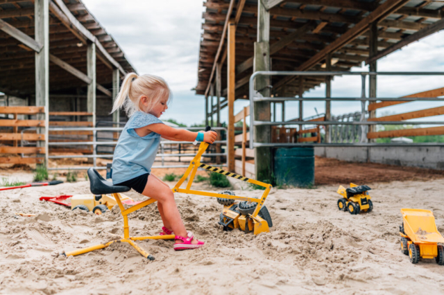 Girl digs in sand at Berger's Breadbasket in Chesapeake, Virginia.