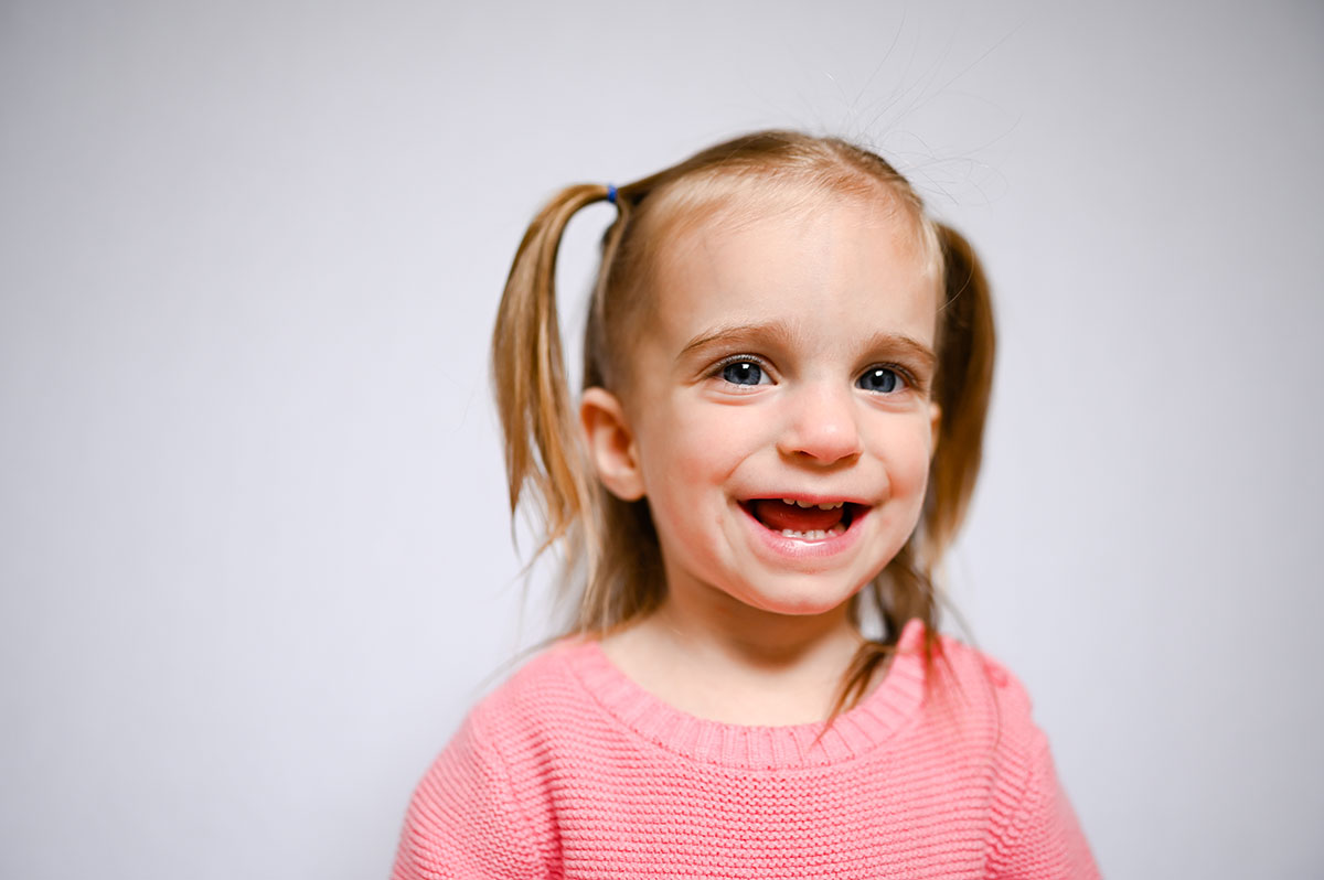 Girl with pigtails smiles during virginia preschools picture day.