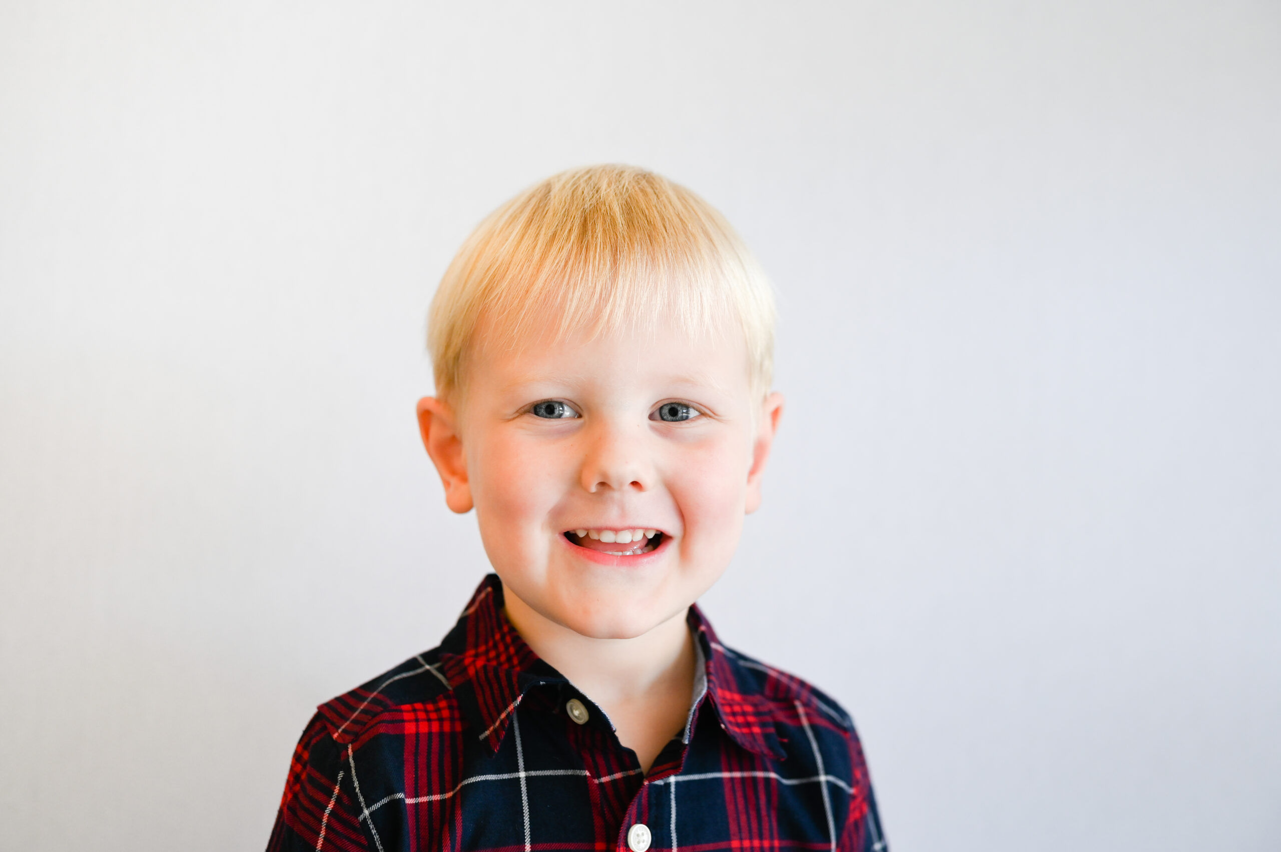 Little boy wears plaid for fall school pictures.