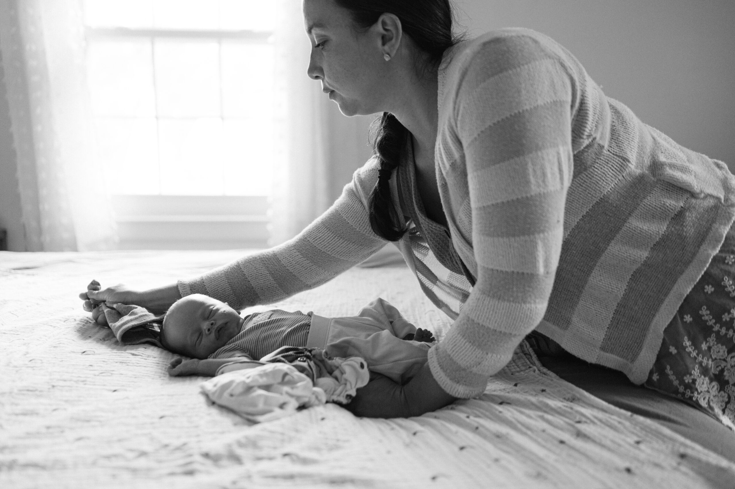 Mom changes baby during in-home newborn session.