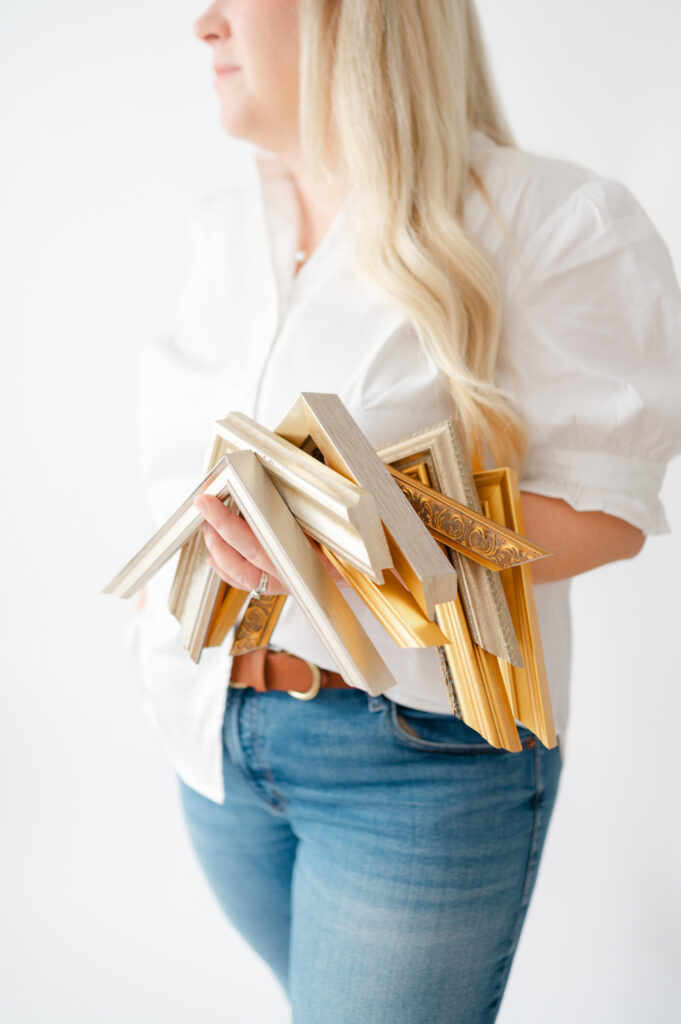 Dreama holding gold and champagne frame corners.