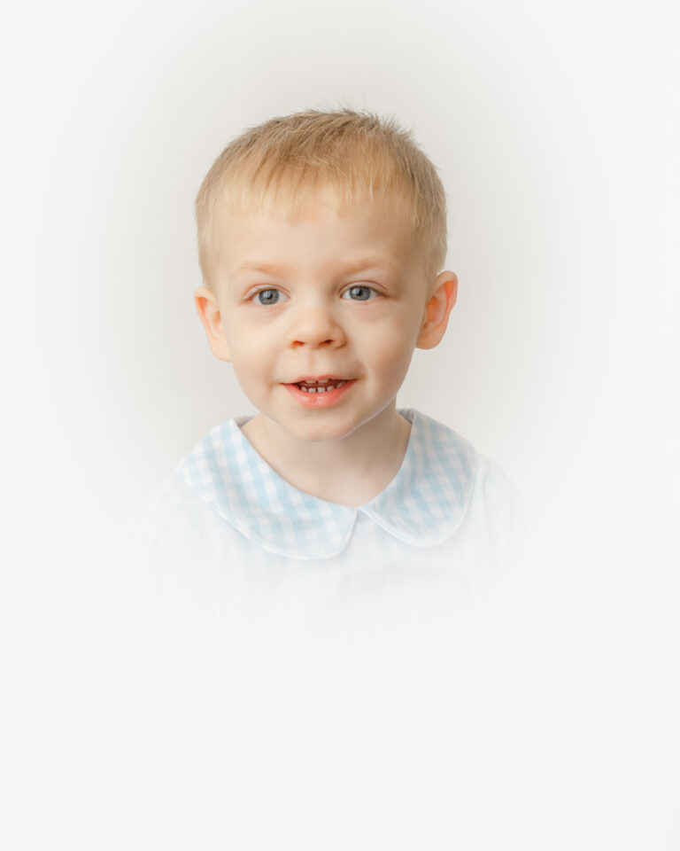 Heirloom portrait of a boy in blue gingham shirt.