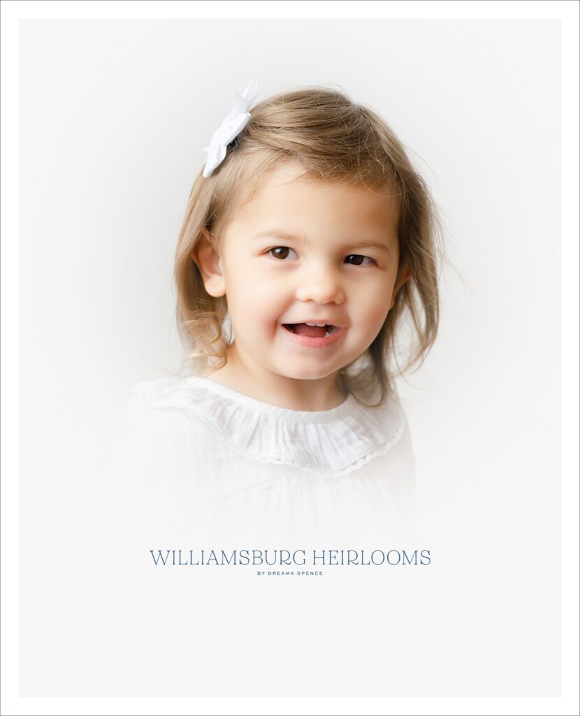 Little girl laughs during her heirloom vignette portrait session in Williamsburg, Virginia.