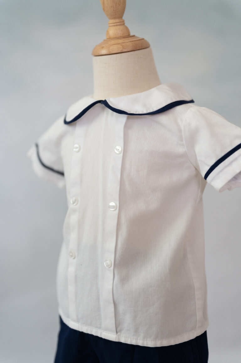 Up close photo of navy piped boys outfit.