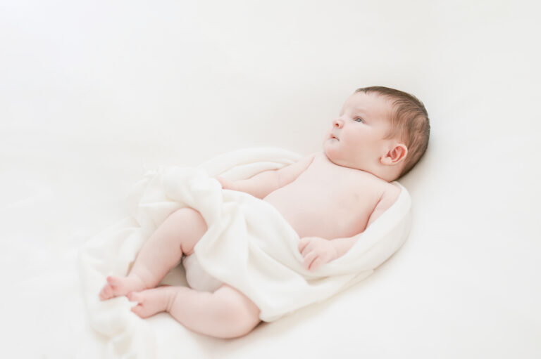Williamsburg newborn photographer baby swaddled in soft white wrap