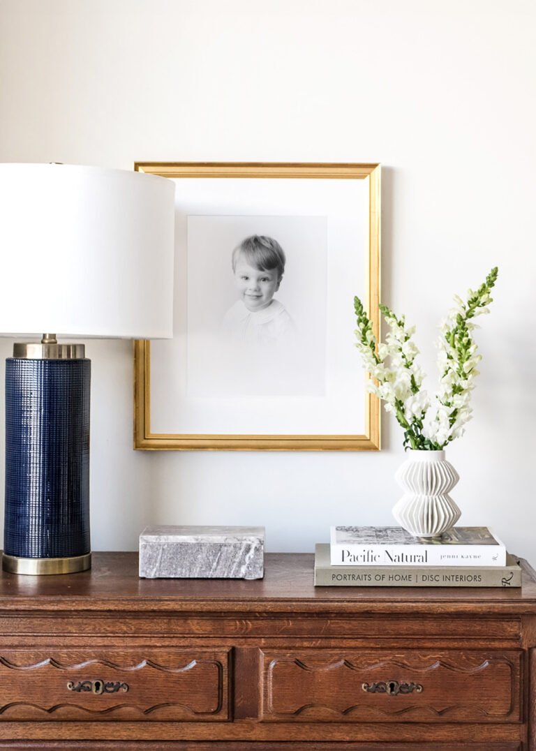 Gold framed heirloom portrait sitting above dining room buffet.