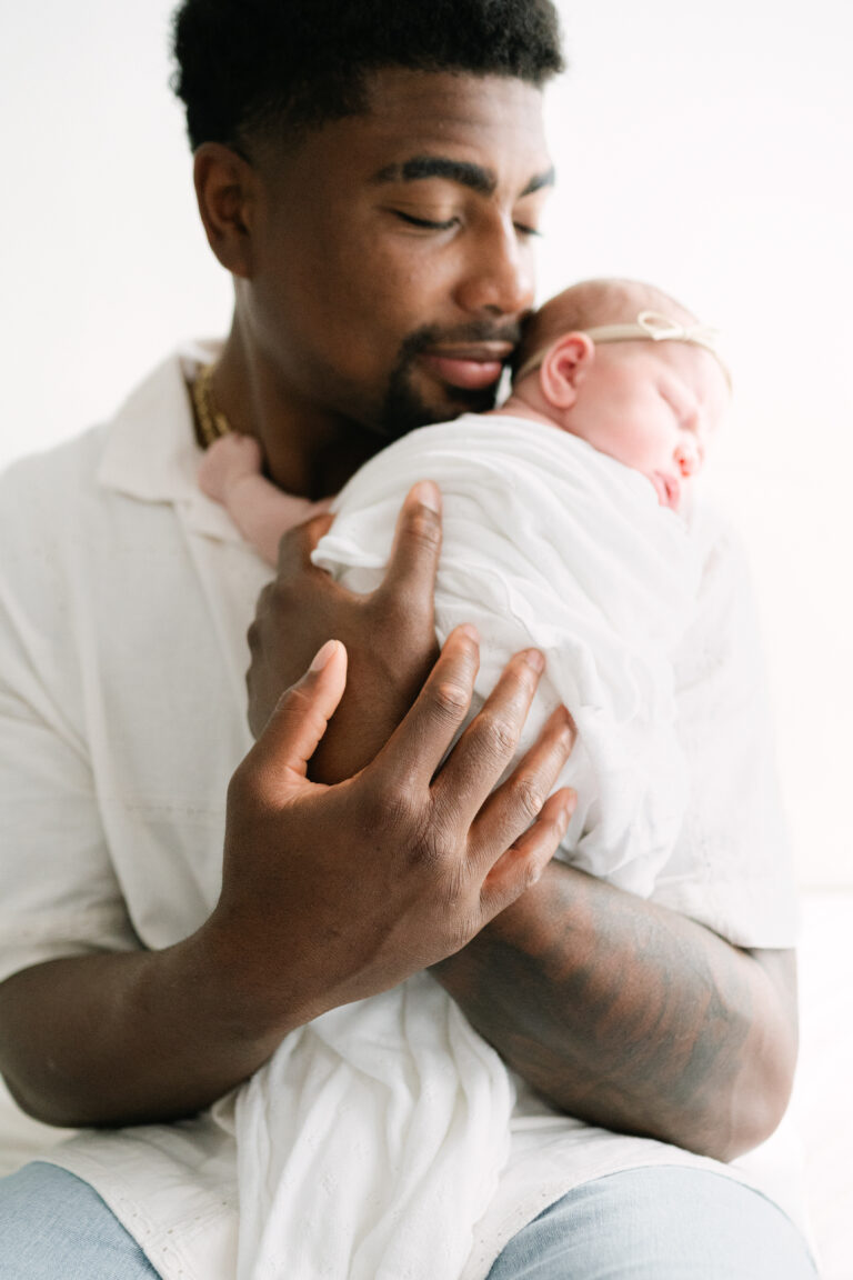 Dad holding newborn daughter.