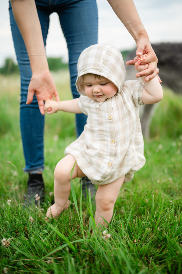 Mom and baby walking through tall grass.