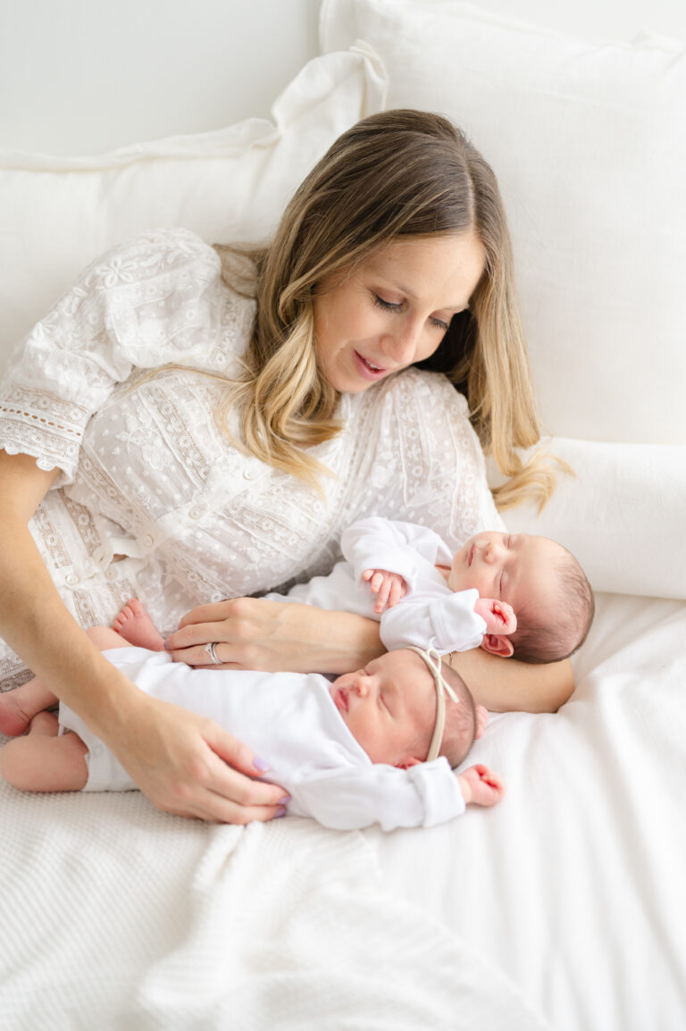 Mother holding her newborn twins during a light and airy Virginia newborn photography session.