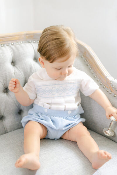 Portrait of little boy with a blue and white smocked outfit.